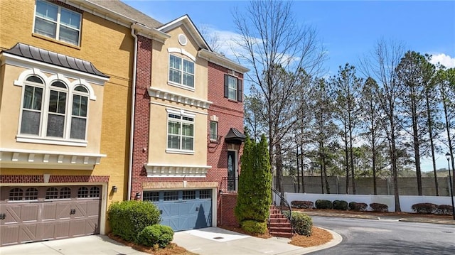 view of front of house with concrete driveway, an attached garage, and brick siding