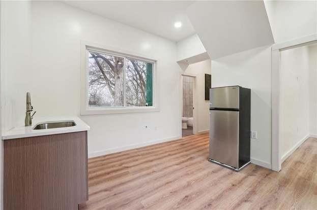 kitchen featuring stainless steel refrigerator, sink, and light wood-type flooring