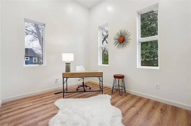 home office with light hardwood / wood-style flooring