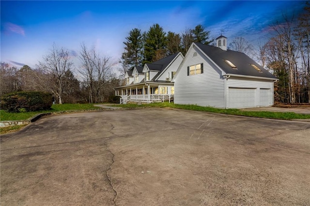 property exterior at dusk with a porch and a garage