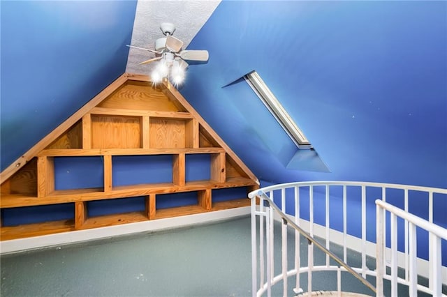 additional living space with ceiling fan and vaulted ceiling with skylight