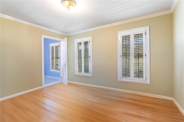 spare room featuring light wood-type flooring and ornamental molding