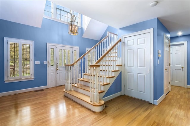 foyer with hardwood / wood-style floors and an inviting chandelier