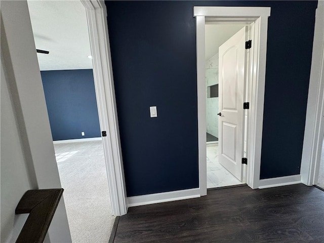 corridor featuring dark wood-style floors and baseboards