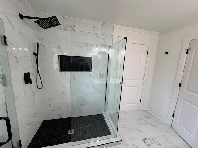 full bathroom with marble finish floor, a shower stall, and baseboards