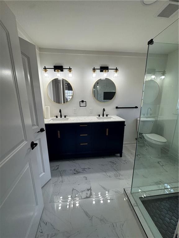 bathroom featuring marble finish floor, a sink, toilet, and double vanity