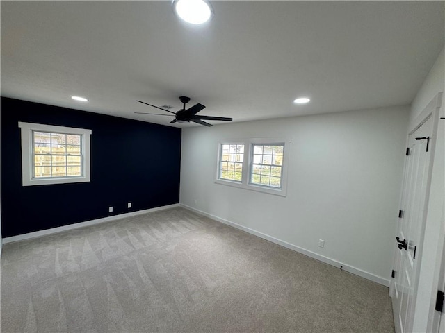 spare room with baseboards, recessed lighting, a ceiling fan, and light colored carpet