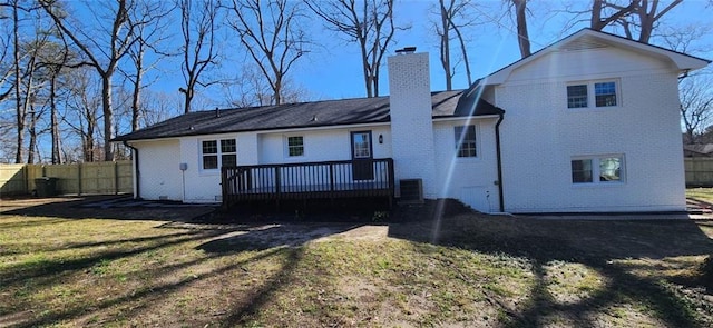 rear view of house featuring a yard, fence, a chimney, and a deck