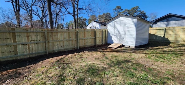 view of yard with a fenced backyard, an outdoor structure, and a shed