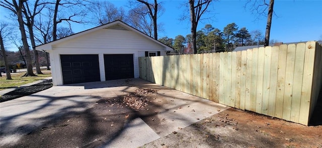 detached garage featuring fence