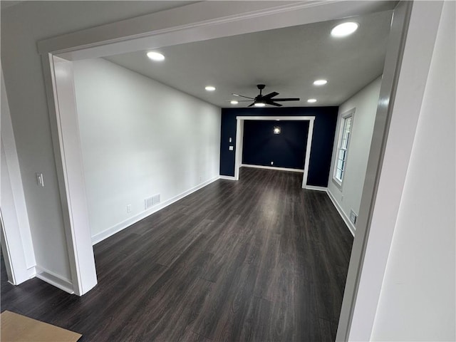 unfurnished room with dark wood-style floors, visible vents, and baseboards