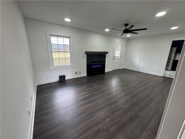 unfurnished living room with recessed lighting, visible vents, dark wood-type flooring, a ceiling fan, and baseboards