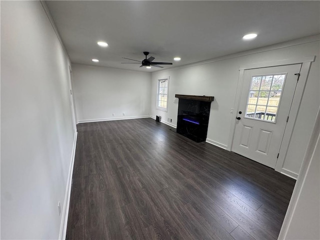 unfurnished living room featuring ceiling fan, recessed lighting, a high end fireplace, baseboards, and dark wood-style floors