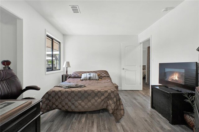 1048 Indian Hills Pkwy, Marietta, GA 30068 - bedroom featuring wood finished floors and a warm lit fireplace
