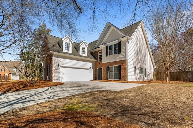 view of front facade featuring brick siding, driveway, and fence