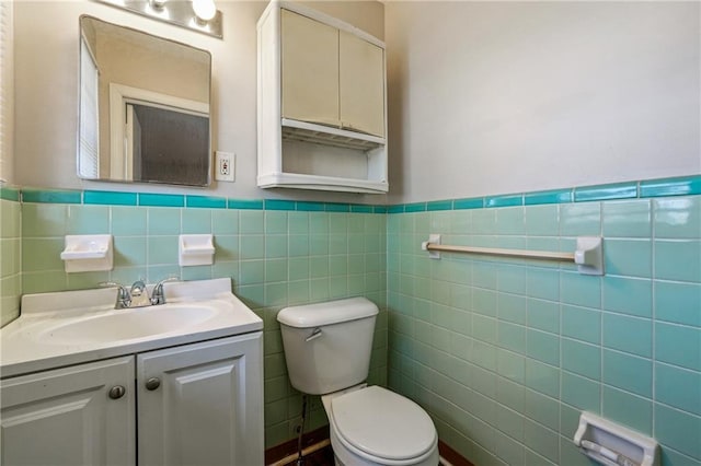 bathroom featuring toilet, vanity, and tile walls