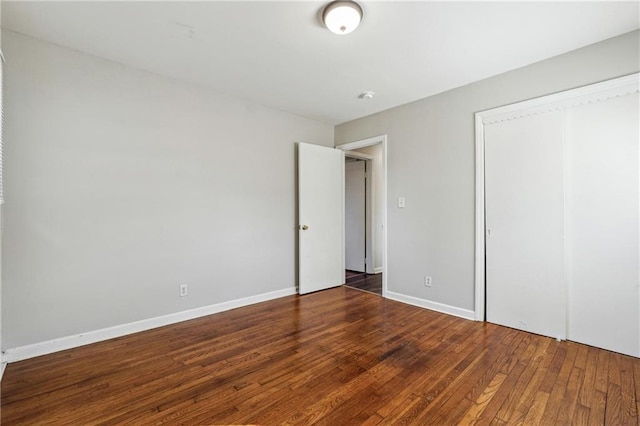 unfurnished bedroom with dark hardwood / wood-style floors and a closet