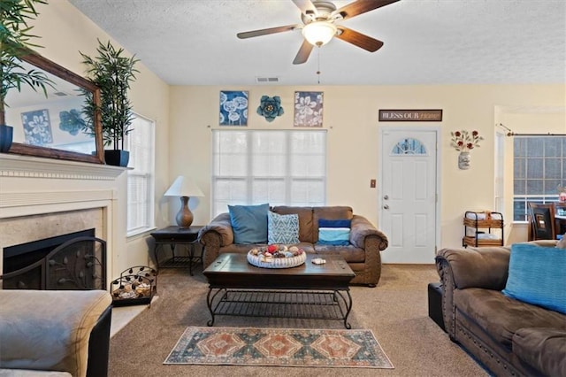 living room with ceiling fan, light carpet, and a textured ceiling