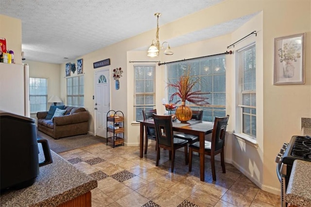 dining space with light tile patterned floors, a notable chandelier, and a textured ceiling