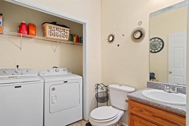 bathroom with vanity, toilet, and separate washer and dryer