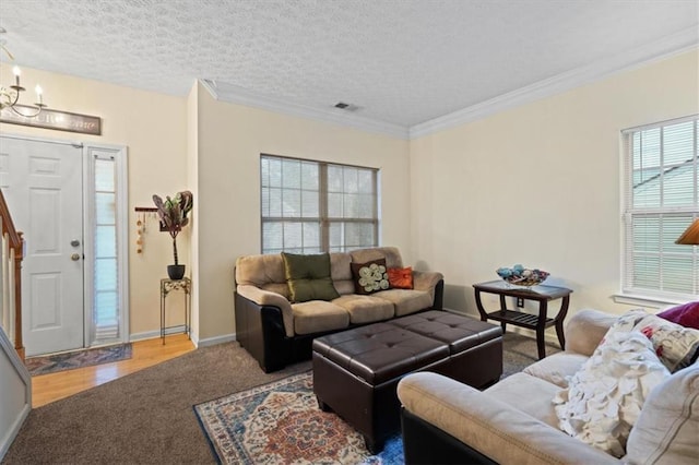 living room featuring ornamental molding, carpet, a notable chandelier, and a textured ceiling