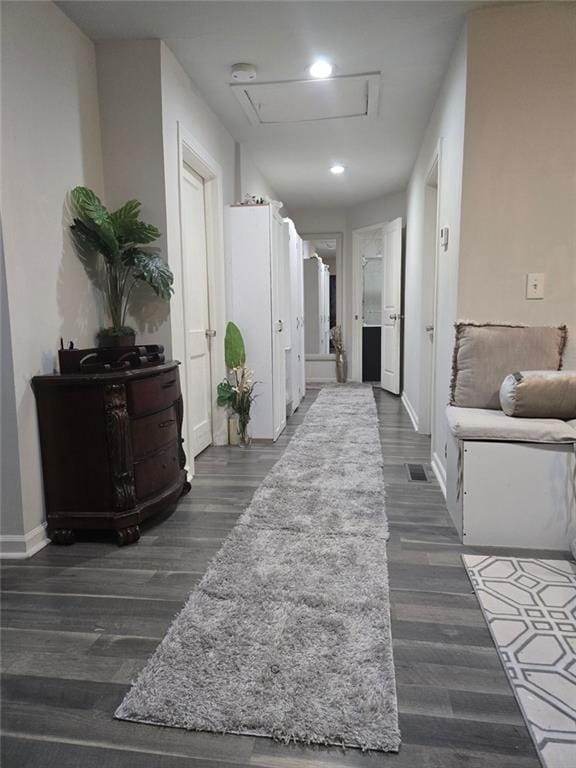 corridor with dark wood-style floors, baseboards, and recessed lighting