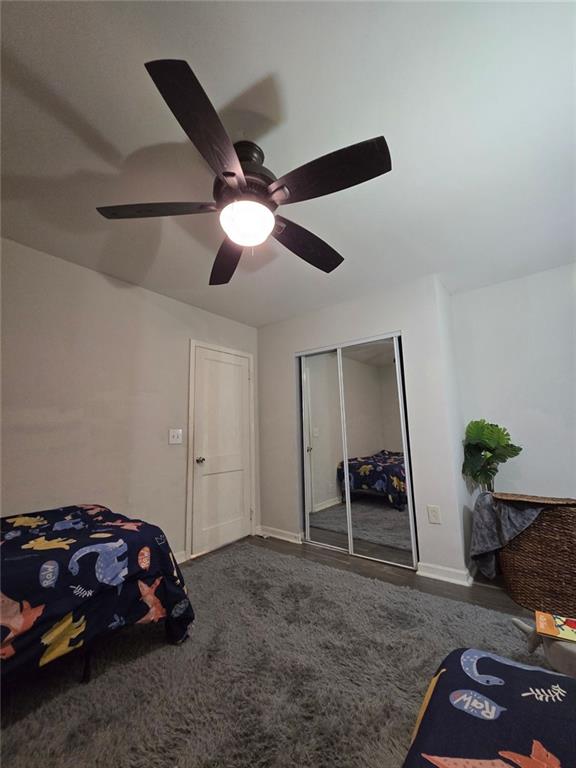 carpeted bedroom with baseboards, a ceiling fan, and a closet