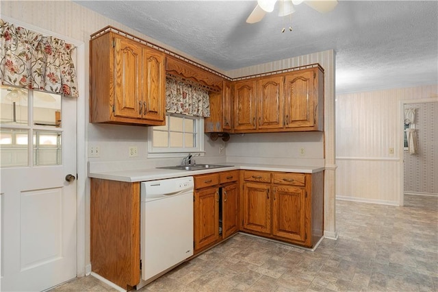 kitchen featuring a textured ceiling, dishwasher, ceiling fan, and sink