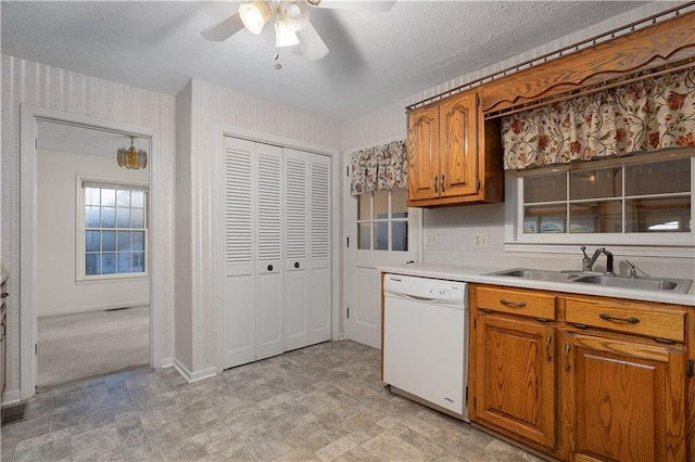 kitchen with white dishwasher, ceiling fan, sink, and a textured ceiling