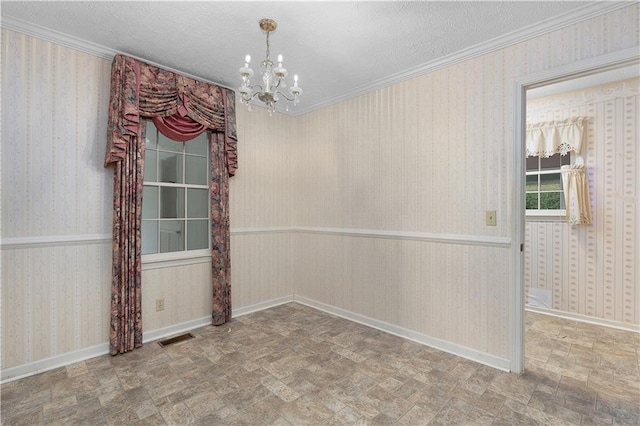 unfurnished room with ornamental molding, a textured ceiling, and a notable chandelier