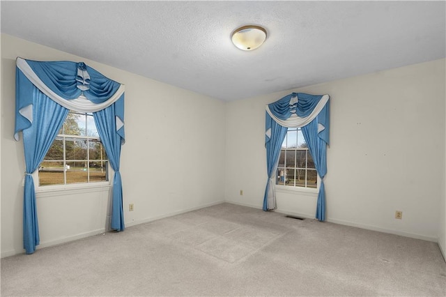 carpeted spare room featuring a textured ceiling