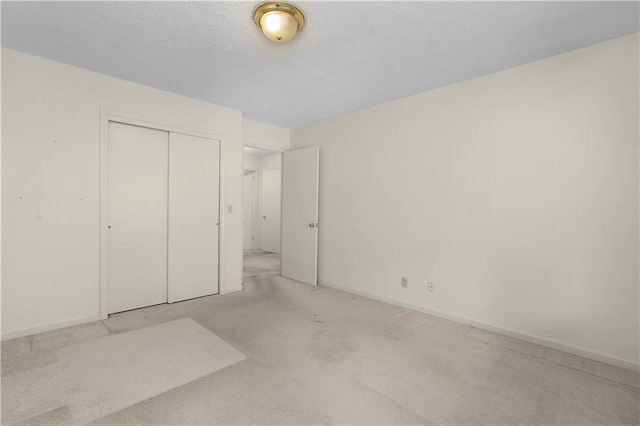 unfurnished bedroom featuring a textured ceiling and a closet