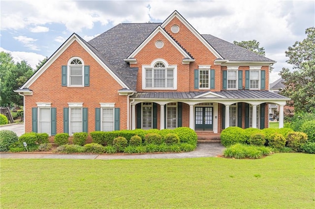 1900 Briergate Dr, Duluth, GA 30097 - view of front of house featuring brick siding, a front yard, covered porch, and a standing seam roof