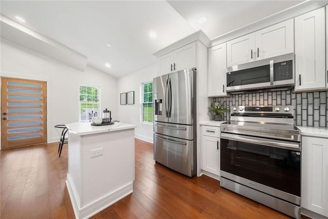 2822 Waters Rd SW, Atlanta, GA 30354 - kitchen with appliances with stainless steel finishes, vaulted ceiling, dark wood finished floors, a center island, and tasteful backsplash