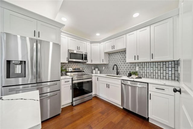 2822 Waters Rd SW, Atlanta, GA 30354 - kitchen with appliances with stainless steel finishes, a sink, white cabinets, tasteful backsplash, and recessed lighting