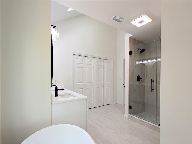 bathroom with a shower stall, double vanity, visible vents, and a sink