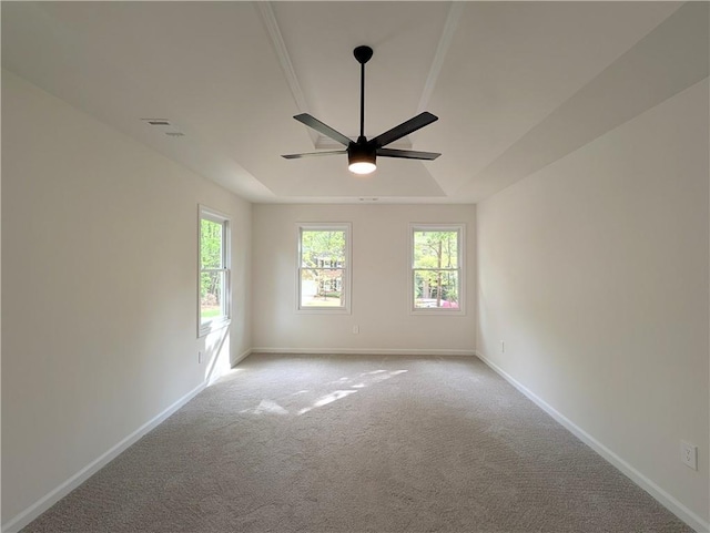 empty room featuring baseboards, carpet floors, a tray ceiling, and a ceiling fan
