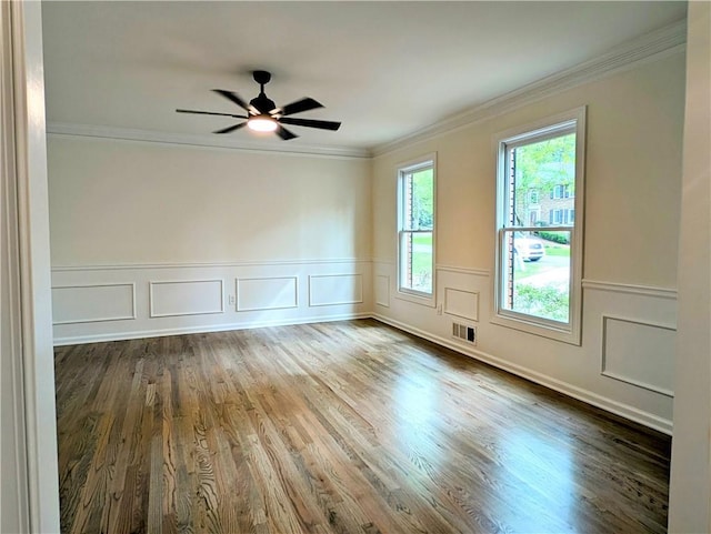 spare room featuring ornamental molding, visible vents, ceiling fan, and wood finished floors