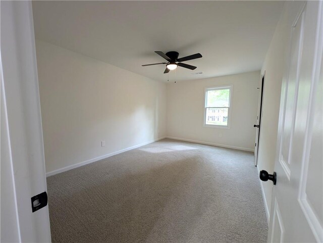 unfurnished room featuring baseboards, visible vents, ceiling fan, and carpet flooring