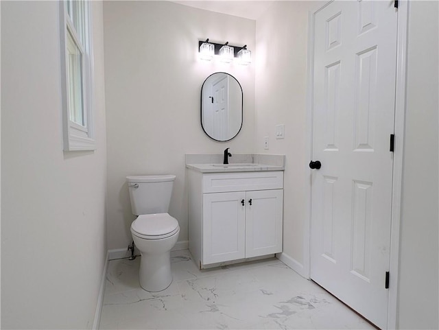 half bath with marble finish floor, baseboards, toilet, and vanity