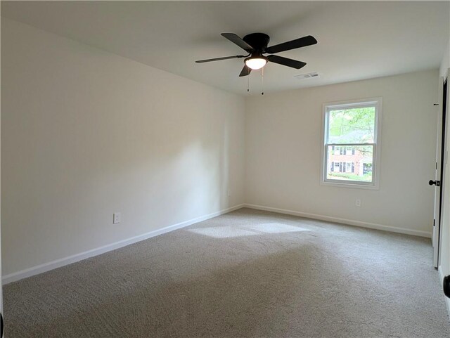 empty room featuring baseboards, visible vents, carpet, and a ceiling fan