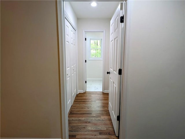 hallway featuring dark wood-type flooring, baseboards, and recessed lighting