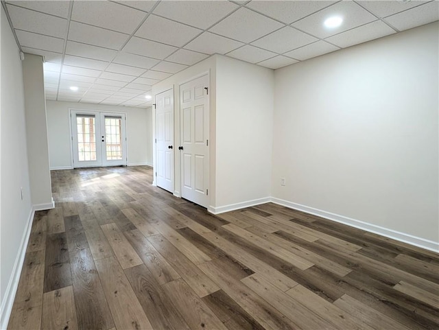spare room with baseboards, dark wood-style floors, french doors, and a paneled ceiling