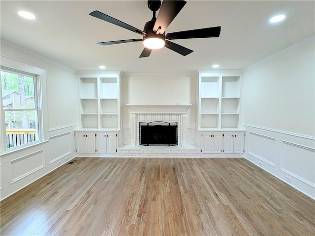 unfurnished living room with ornamental molding, built in features, and a decorative wall