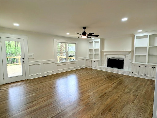 unfurnished living room featuring a ceiling fan, a healthy amount of sunlight, and wood finished floors