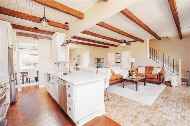 kitchen featuring white cabinetry, stainless steel appliances, sink, and hanging light fixtures