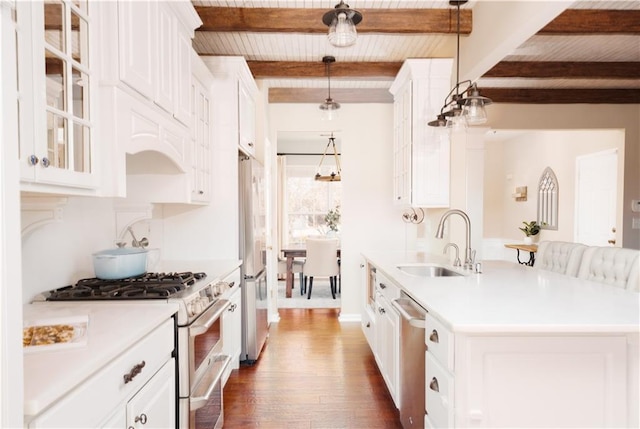 kitchen featuring decorative light fixtures, beamed ceiling, sink, white cabinets, and stainless steel appliances