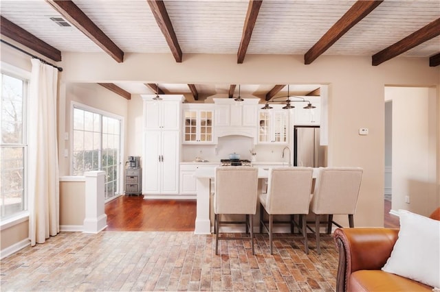 dining area with wood ceiling, ceiling fan, beam ceiling, and sink