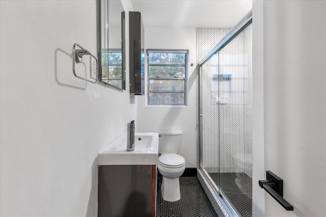 bathroom with tile patterned floors, vanity, an enclosed shower, and toilet