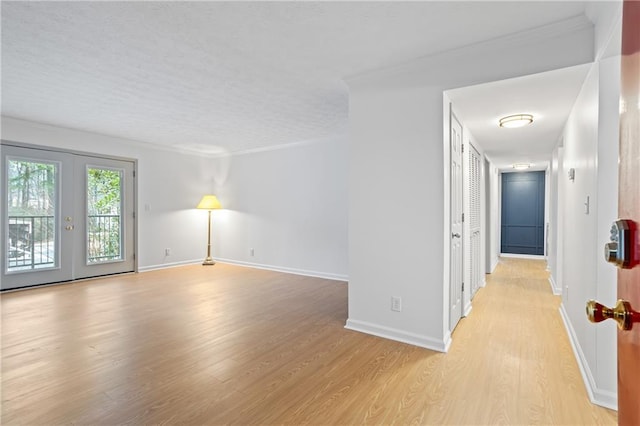 spare room with french doors, light hardwood / wood-style flooring, and crown molding